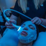 A relaxing spa facial treatment with a light therapy device for skincare rejuvenation.